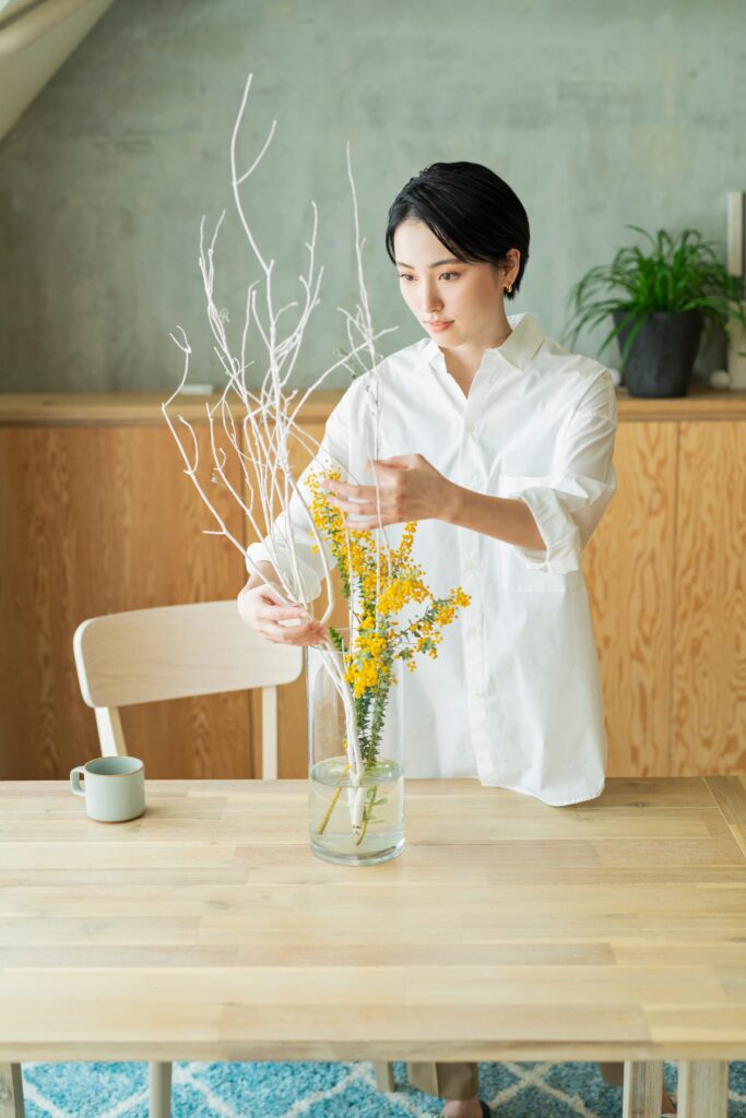 リビングで花を生けている女性